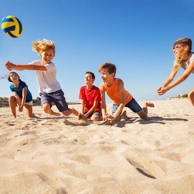 Kinder spielen am Strand Volleyball